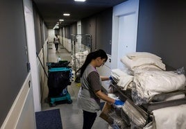 Una camarera de piso, limpiando las habitaciones de un hotel.