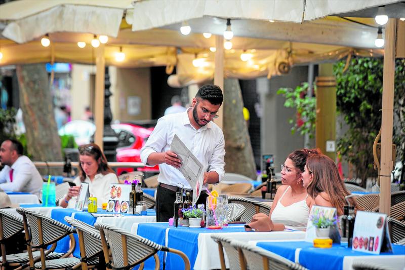Un camarero atiende a una mesa en las Ramblas, a 15 de junio de 2022, en Barcelona.